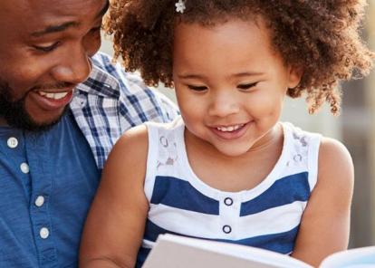 man reading to a little girl